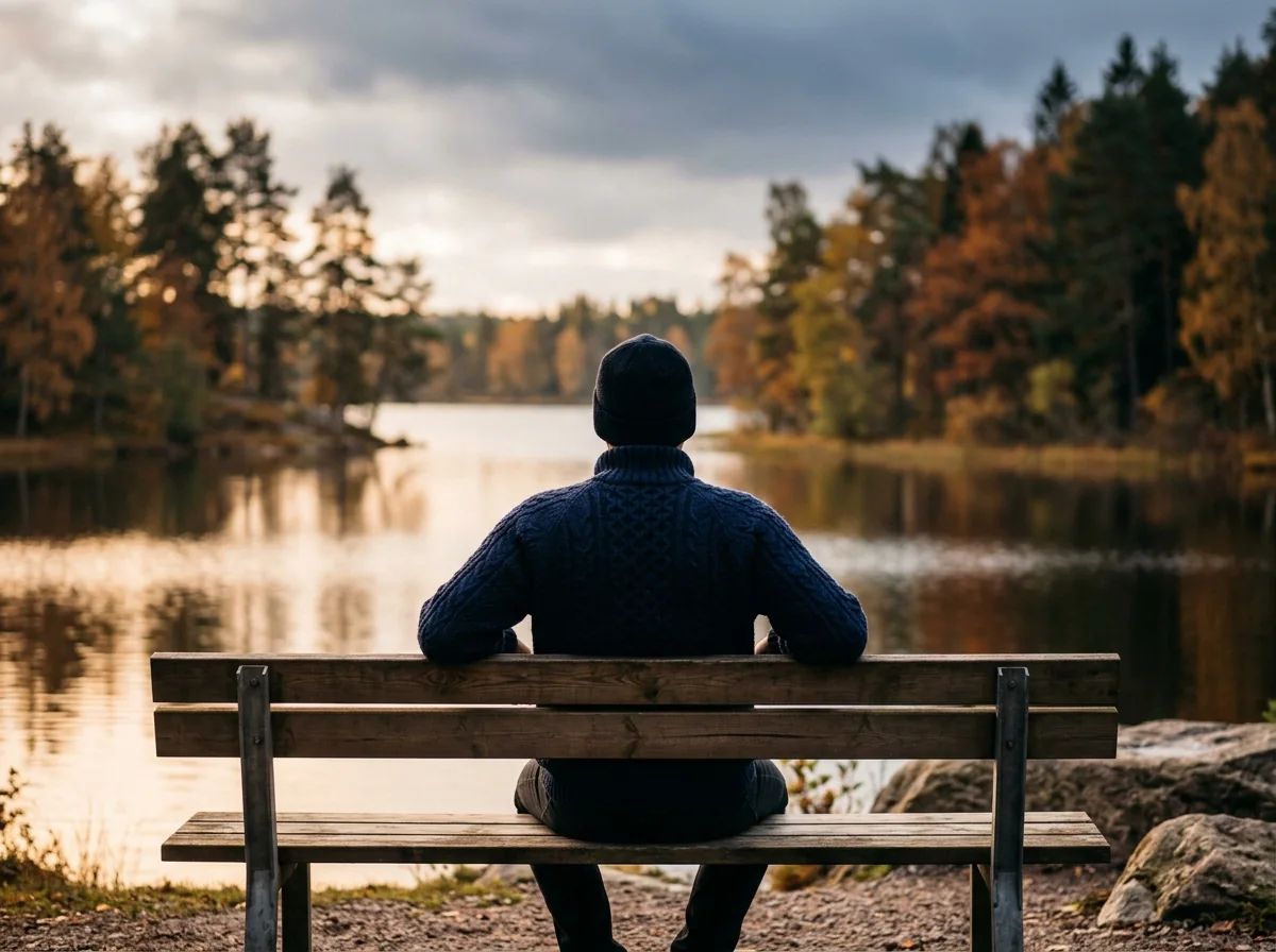 Anonym person sitter utomhus vid en sjö i Sverige - illustrativ livsstilsbild